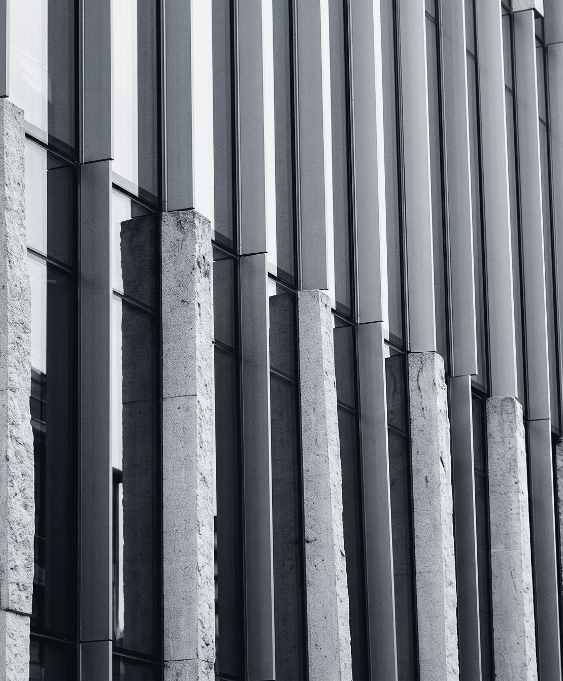 Architectural detail of stone columns and glass facade